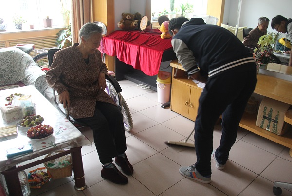 志愿者帮老奶奶打扫卫生 生科院 胡梦佳 摄